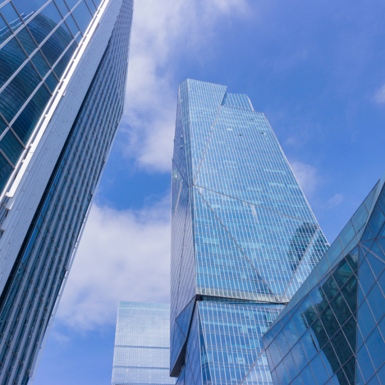 Moderne Wolkenkratzer mit Glasfassaden unter einem blauen Himmel.